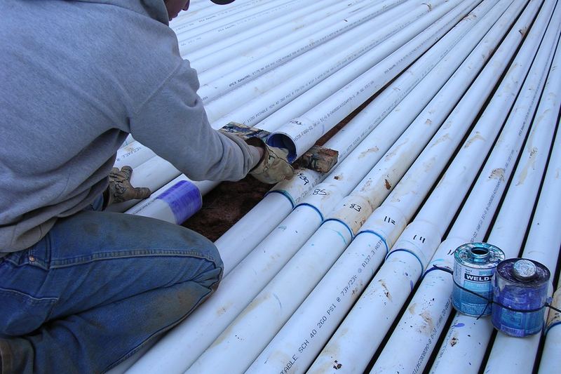 Installer priming and gluing PVC pipe joints on site