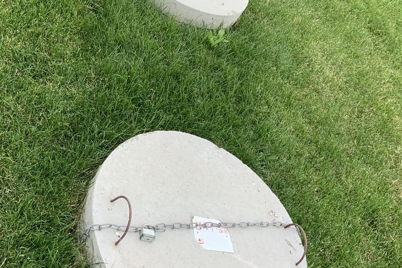 Round septic tank access covers set into a lawn